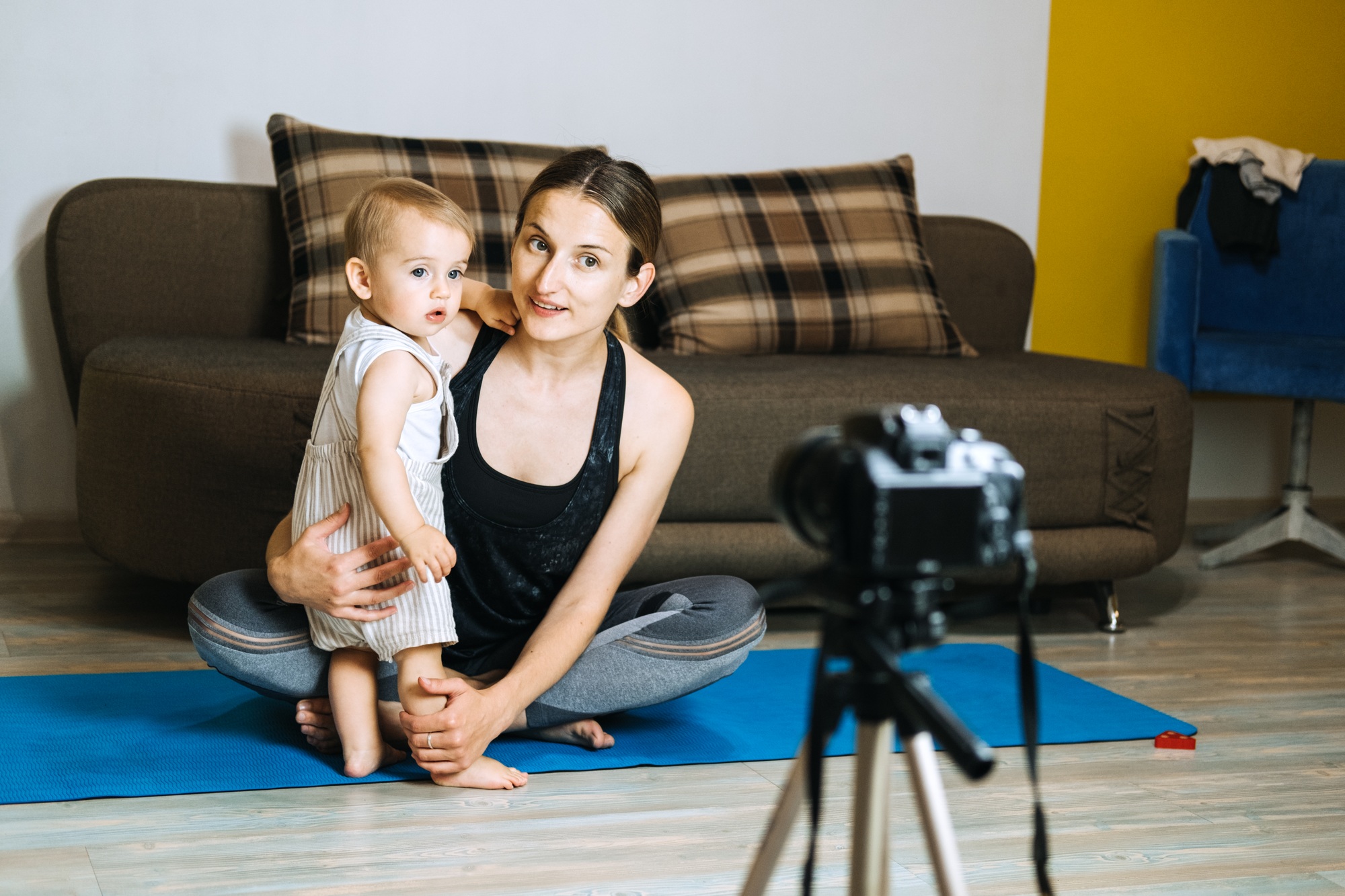 Mom blogger records video on camera with her little daughter at home.