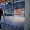 A 'We Accept Food Stamps' sign hangs in the window of a grocery store in Miami.